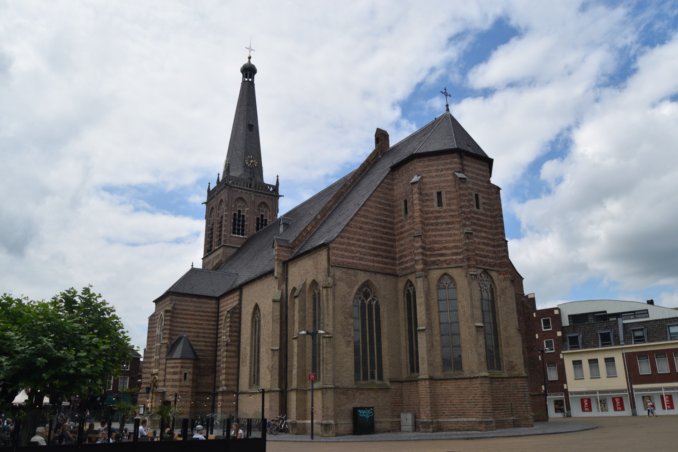 The Catharinakerk seen from Simonsplein on an ordinary afternoon, brick and stone under a clouded sky.